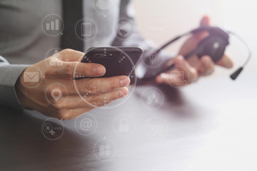 caption: Businessman using VoIP headset with mobile phone and concept communication call center.