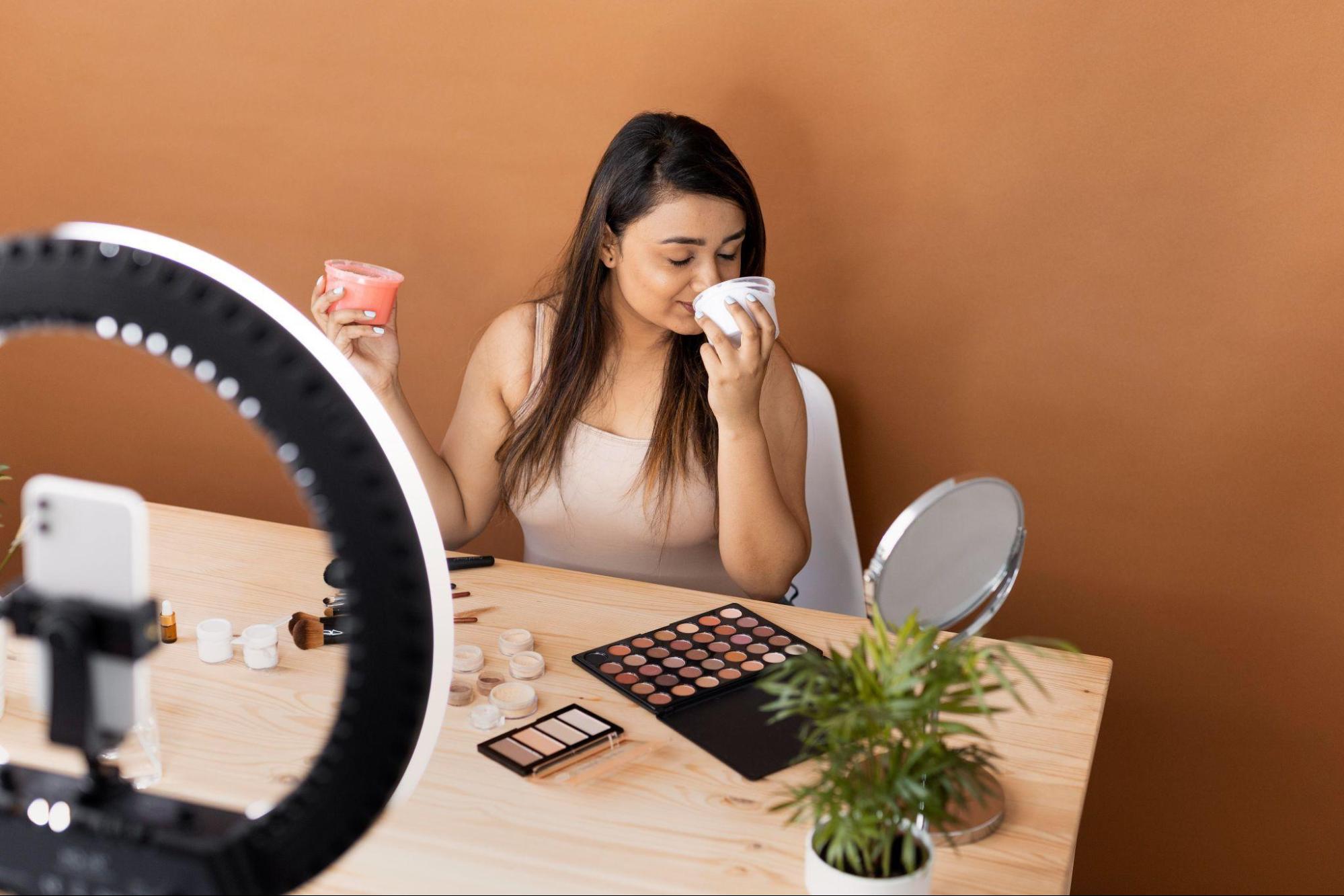 A woman smelling a skincare product while shooting a video.